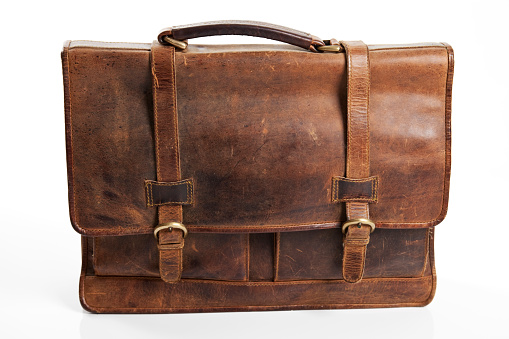 Old suitcase isolated on white background. Brown leather vintage suitcase with metal brackets on the corners and a lock. Baggage.