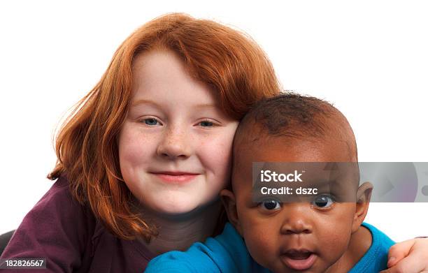 Dziecko W Wieku Szkoły Podstawowej Redhead Dziewczyna Objąć Co 6 Miesięcy Stary Przyjęła Czarny Siostra - zdjęcia stockowe i więcej obrazów Siostra