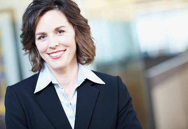 Close-up of a happy mature businesswoman in office Portrait of a smiling successful business woman at work medium length hair stock pictures, royalty-free photos & images