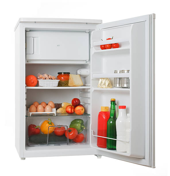 Stocked white mini fridge with produce and eggs