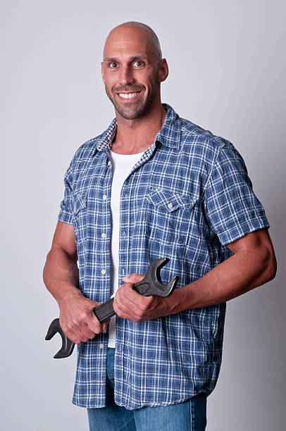 istock smiling man holding a wrench 182827300