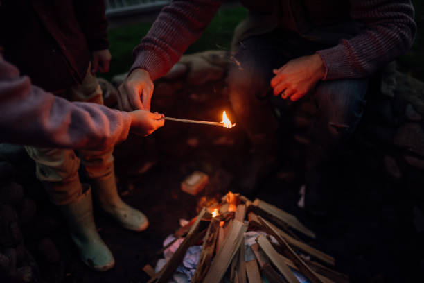 istock The family spending evening outdoors, lighting fire in a fire pit. Prents and kids spending quality family time together. 1828273223