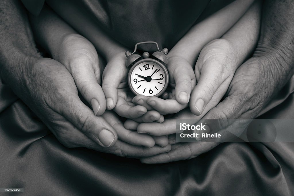 Family Time "The hands of three generations of one family (Grandmother, Mother and Daughter) holding a clock." Clock Stock Photo