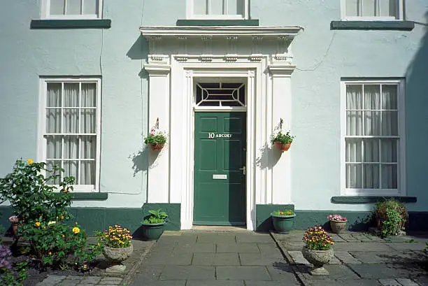 Some... vagueness in the address of this English home: written on the front door are many house numbers. 