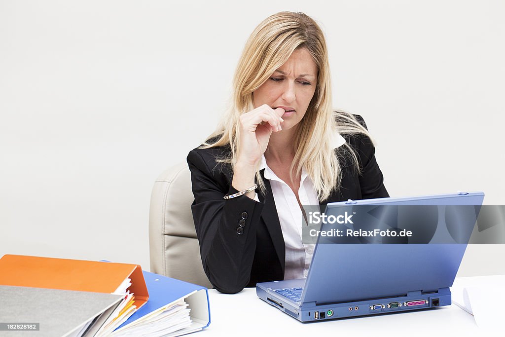 Zdenerwowany blond Biznesmenka siedzi na laptopie Obgryzanie paznokci - Zbiór zdjęć royalty-free (30-39 lat)