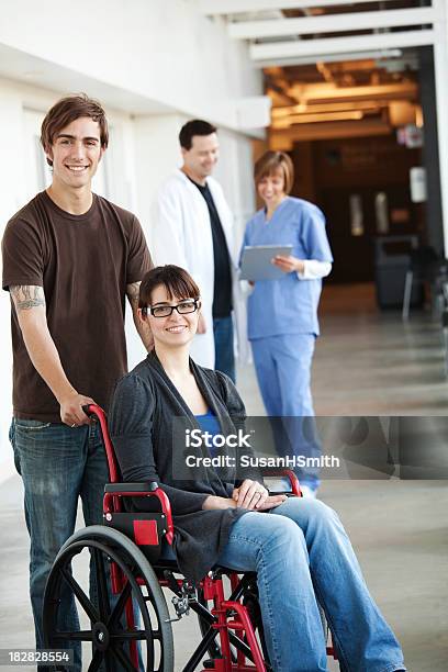 Ospedalecoppia Con Sedia A Rotelle - Fotografie stock e altre immagini di Sedia a rotelle - Sedia a rotelle, Uomini giovani, Abbigliamento casual