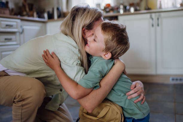 istock Mother saying goodbyeto to son before school, hugging, embracing him in kitchen. 1828288063