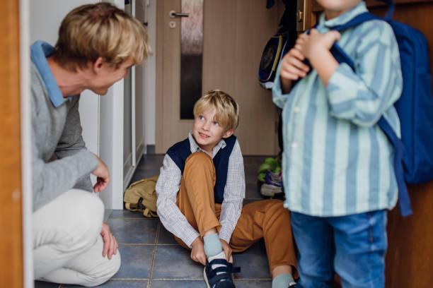 istock Children getting ready for school, putting on shoes, getting dressed. Father taking them to school and kindergarten before going to work. 1828288573