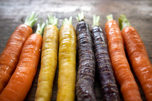 Various colorful baby carrots, nutritious and healthy food on a wooden background
