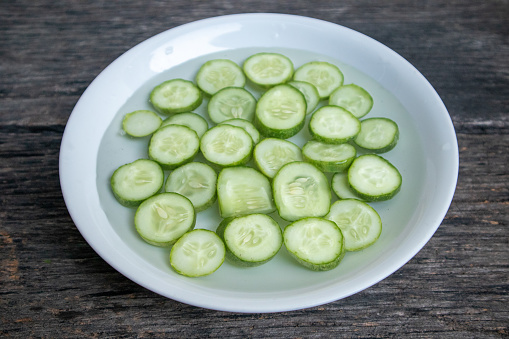 Cucumber cut into pieces and soaked in water to prepare for facial mask and skin care.