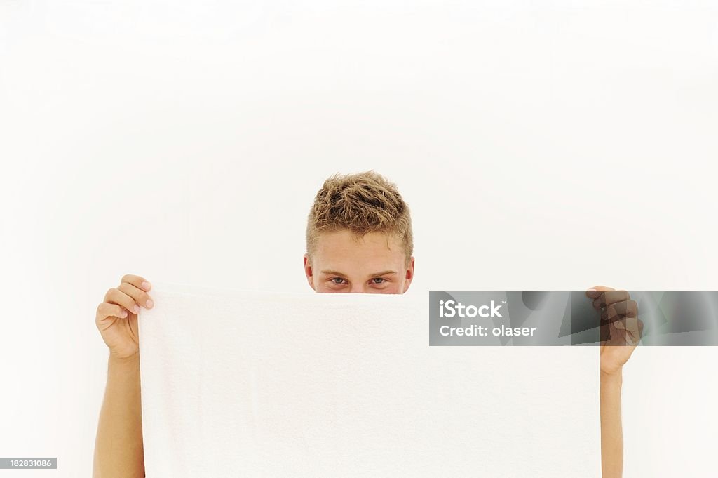 Улыбающегося молодой взрослый Выглядывать за полотенце - Стоковые фото Белый роялти-фри