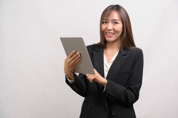 istock Young asian businesswoman using tablet over white background, technology concept 1828312534