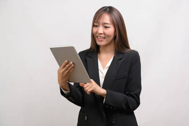 istock Young asian businesswoman using tablet over white background, technology concept 1828313606