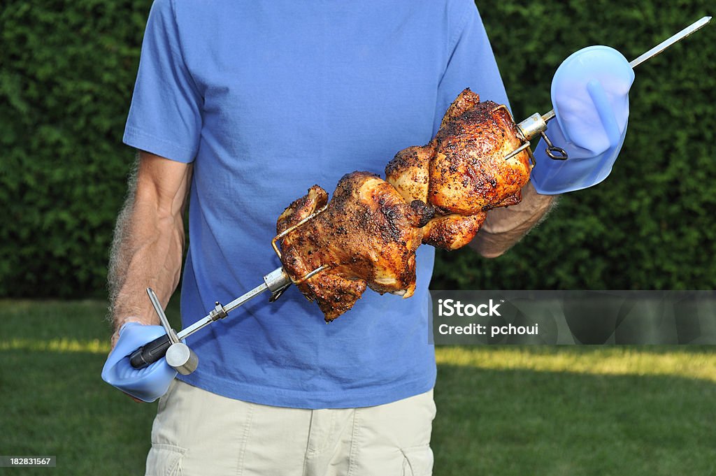 Hombre con barbacoa pollo asado al pincho, parrilla al aire libre con cocina a la vista - Foto de stock de Pollo asado libre de derechos