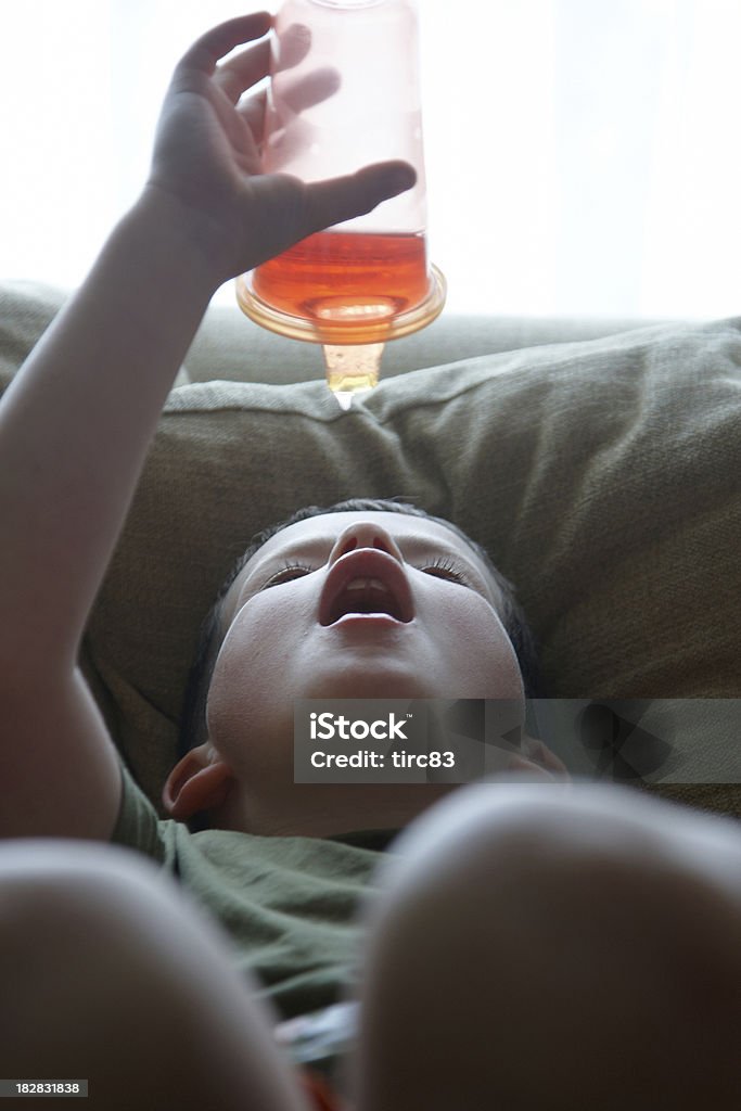 Garoto escorrendo suco em sua boca - Foto de stock de Caneca para Bebê royalty-free