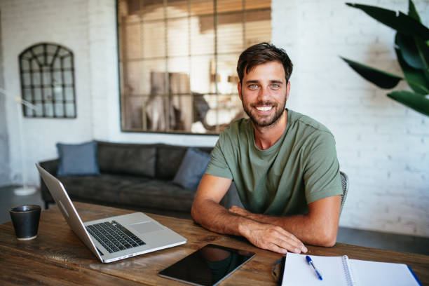 istock Young handsome man working from home, looking at camera during the coffee break 1828325196