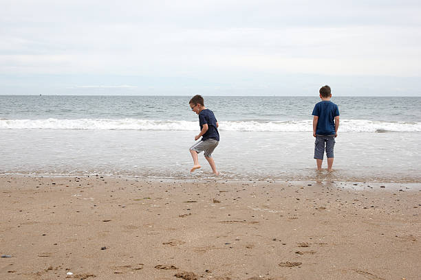 istock Two young boys at the water's edge 182832659