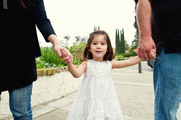 istock holding mom and dads hand outside 182832788