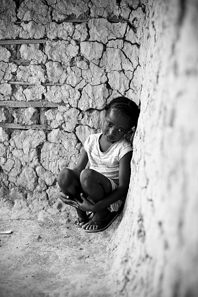 African Girl An African girl sitting in a corner looking sad. sad girl crouching stock pictures, royalty-free photos & images