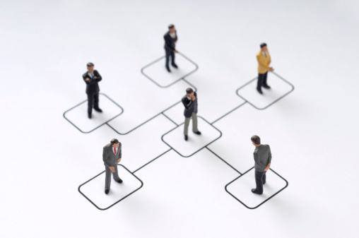 6 Businessmen figurines standing on organization chart
