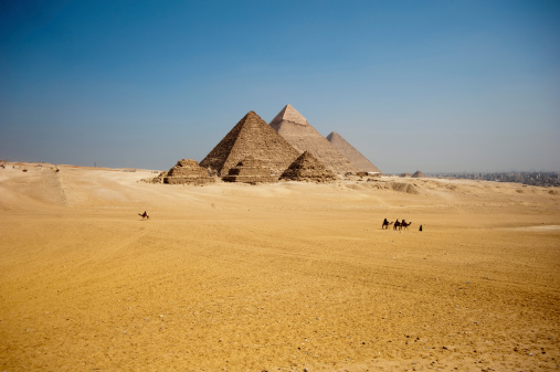 Giza pyramids with a camel train.