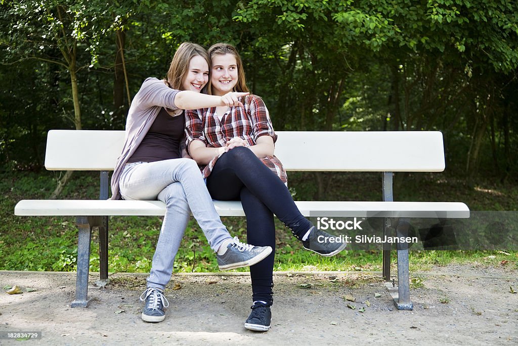 teenager girls sitting on a bench 2 teenager girls and best friends, having fun in summer 14-15 Years Stock Photo