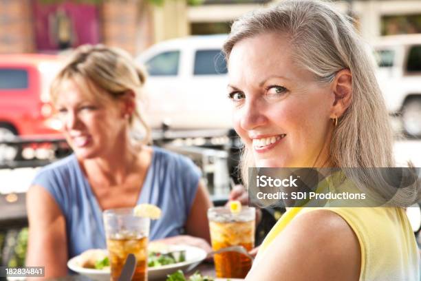 Donna Guardando Indietro Avendo Pranzo In Ristorante Allaperto - Fotografie stock e altre immagini di Abbigliamento casual