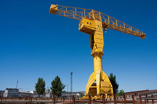 Giant yellow crane towering over landscape Grue Titan jaune - Yellow Titan Crane on the old docks of île Beaulieu in Nantes. Industrial Heritage of the île de Nantes, France. A very dynamic urban and architectural transforming place. nantes stock pictures, royalty-free photos & images