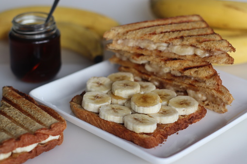 Sumptuous honey banana toast sandwich, golden bread layers with fresh sliced bananas, drizzled with sweet honey, delicious breakfast concept
