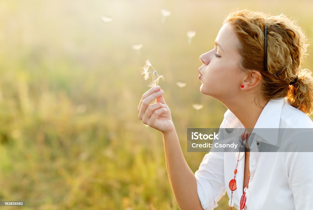 Молодая женщина, дуть в виде одуванчиков - Стоковые фото Аллергия роялти-фри