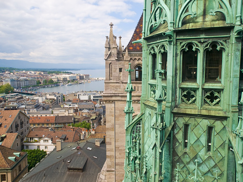 Cathedral Saint Pierre in Geneva, Switzerland. View from above on copper tower, lake with fountain and houses around the lake. Scenic sunny day. 