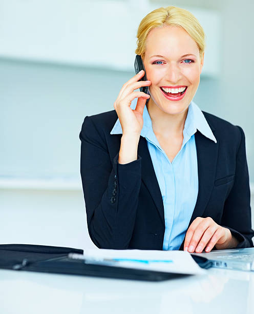 istock Elegant business woman talking over cellphone at work 182836301