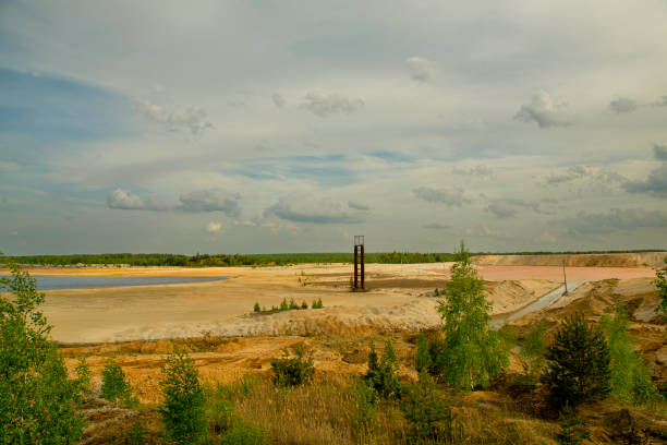 Granite quarry for iron ore extraction. Pond with red water after mining. Industrial landscape. Problems of ecology and environment.