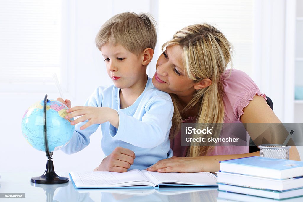 Mother and son globe used in learning. Mother and son in the living room to learn and use the globe for it. Adult Stock Photo