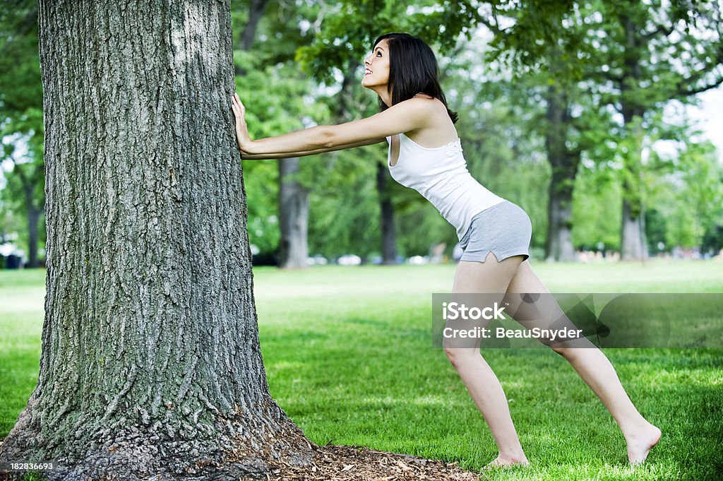 Étirements contre un arbre - Photo de 20-24 ans libre de droits