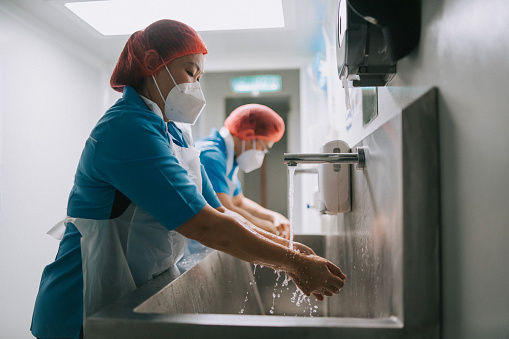 Asian Chinese factory workers washing hands cleaning before entering clean room stock photo