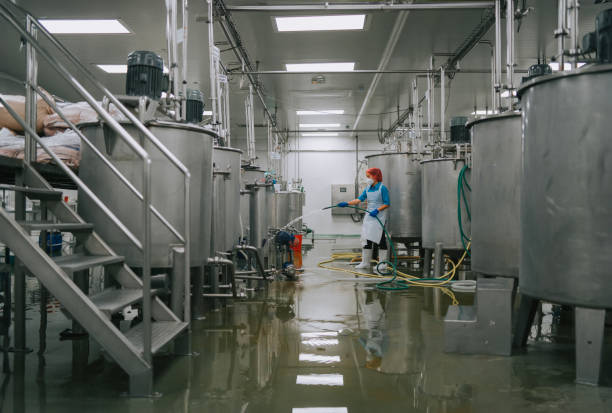 istock Factory worker cleaning flooring Factory interior storage tank section Filtering Machine and Tanks after production completed 1828370995