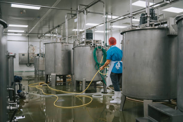 istock Factory worker cleaning flooring Factory interior storage tank section Filtering Machine and Tanks after production completed 1828371063