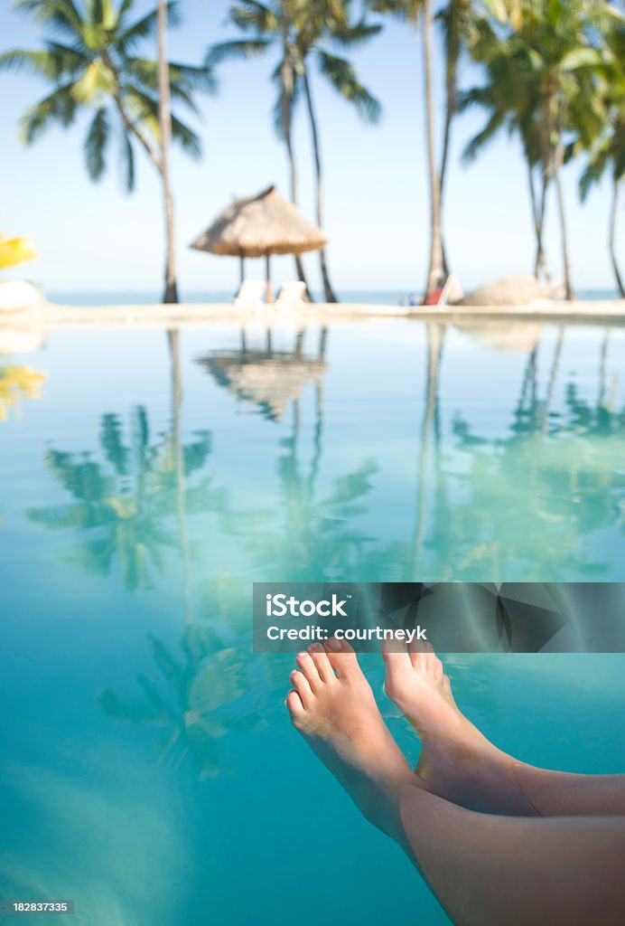 Mujer con pies en la piscina de relajación - Foto de stock de Playa libre de derechos