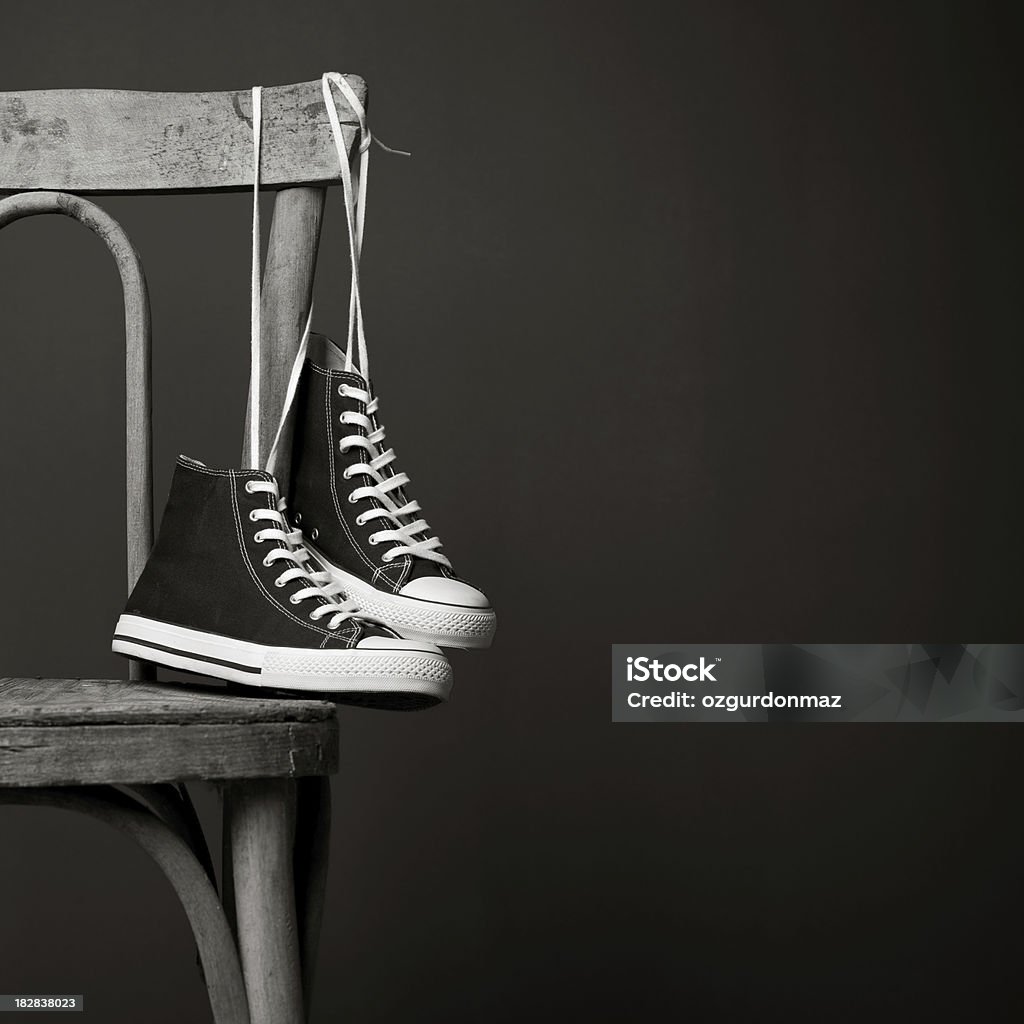 Sneaker appeso su una sedia - Foto stock royalty-free di Abbandonato