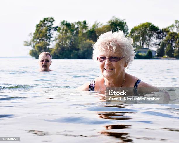 Senior Donna Nuotare Nel Lago - Fotografie stock e altre immagini di Fiume - Fiume, Nuoto, Canada