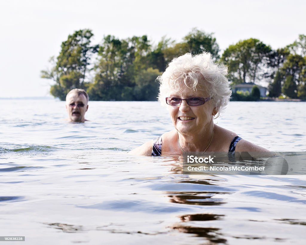 Starszy kobieta pływanie w jeziorze - Zbiór zdjęć royalty-free (Pływać)