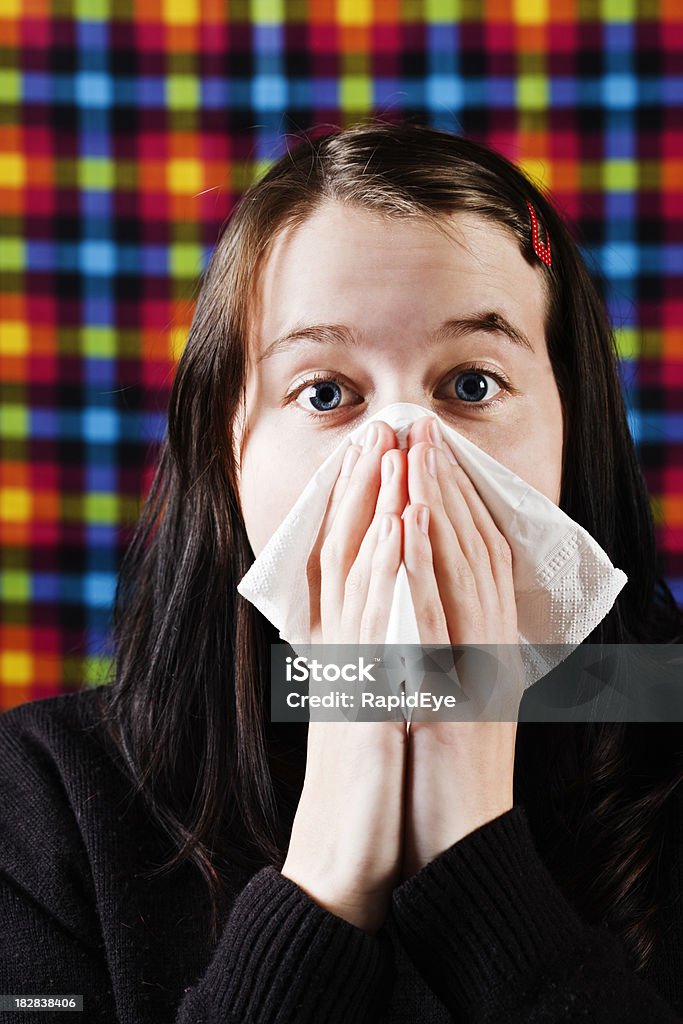 Giovane donna sneezes e soffia il naso - Foto stock royalty-free di Adulto
