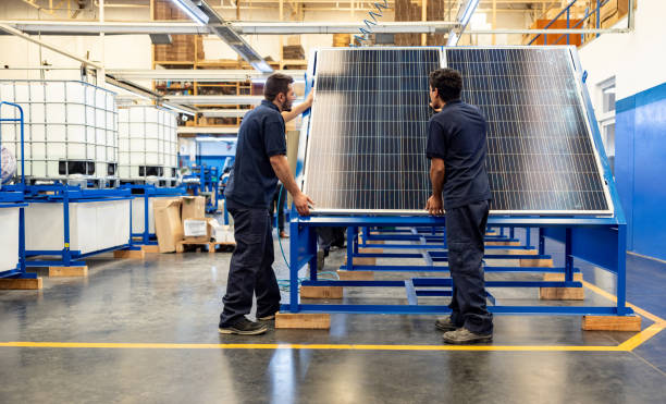 Engineers installing solar panels at a factory Green technology engineers installing solar panels at a manufacturing factory solar panel manufacturing stock pictures, royalty-free photos & images
