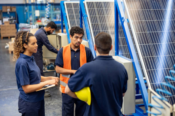 istock Group of employees working at a solar panel factory 1828385360