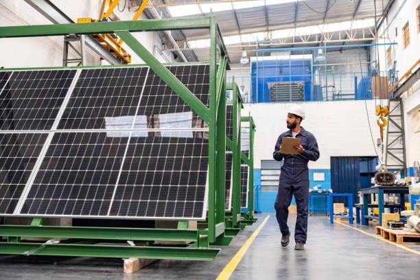Engineer supervising the production of solar panels at a factory Indian engineer supervising the production of solar panels at a factory and taking notes on a clipboard solar panel manufacturing stock pictures, royalty-free photos & images