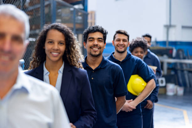 istock Happy group of warehouse workers in a row and smiling 1828385970