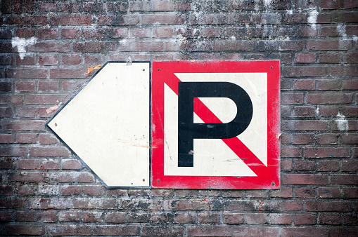 No parking sign on brick wall