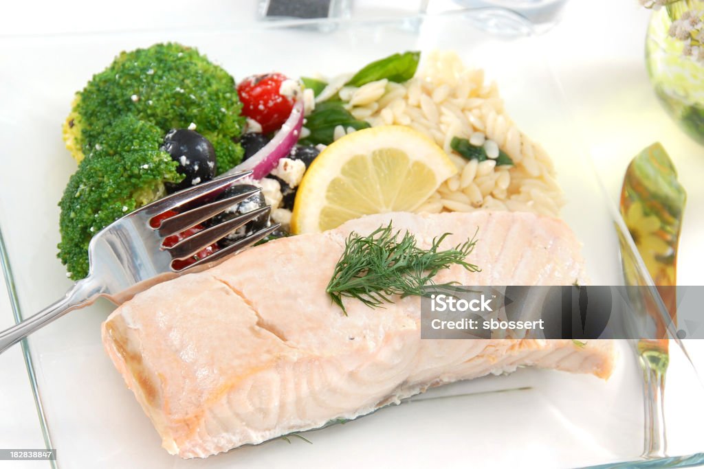 Poached salmon with lemon and seasoning A light meal of poached salmon with an orzo and vegetable salad.  Perfect for a summer luncheon.More images of poached salmon: Poached Salmon Stock Photo