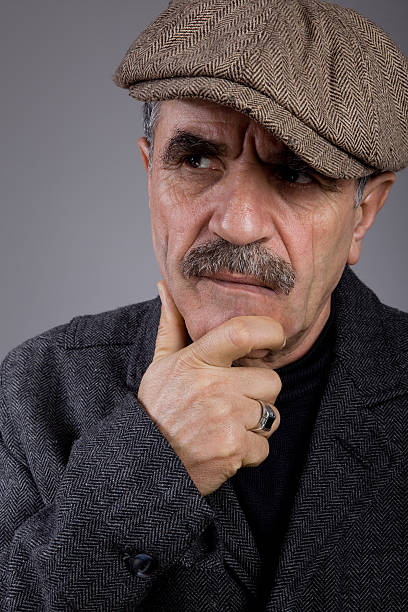 istock Senior men with newsboy cap contemplating 182839112